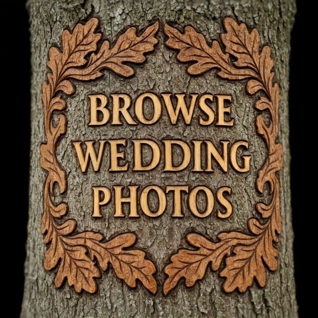 An intricate wooden sign carved directly into tree bark, featuring a deeply chiseled oak leaf frame surrounding the raised text "BROWSE WEDDING PHOTOS".
