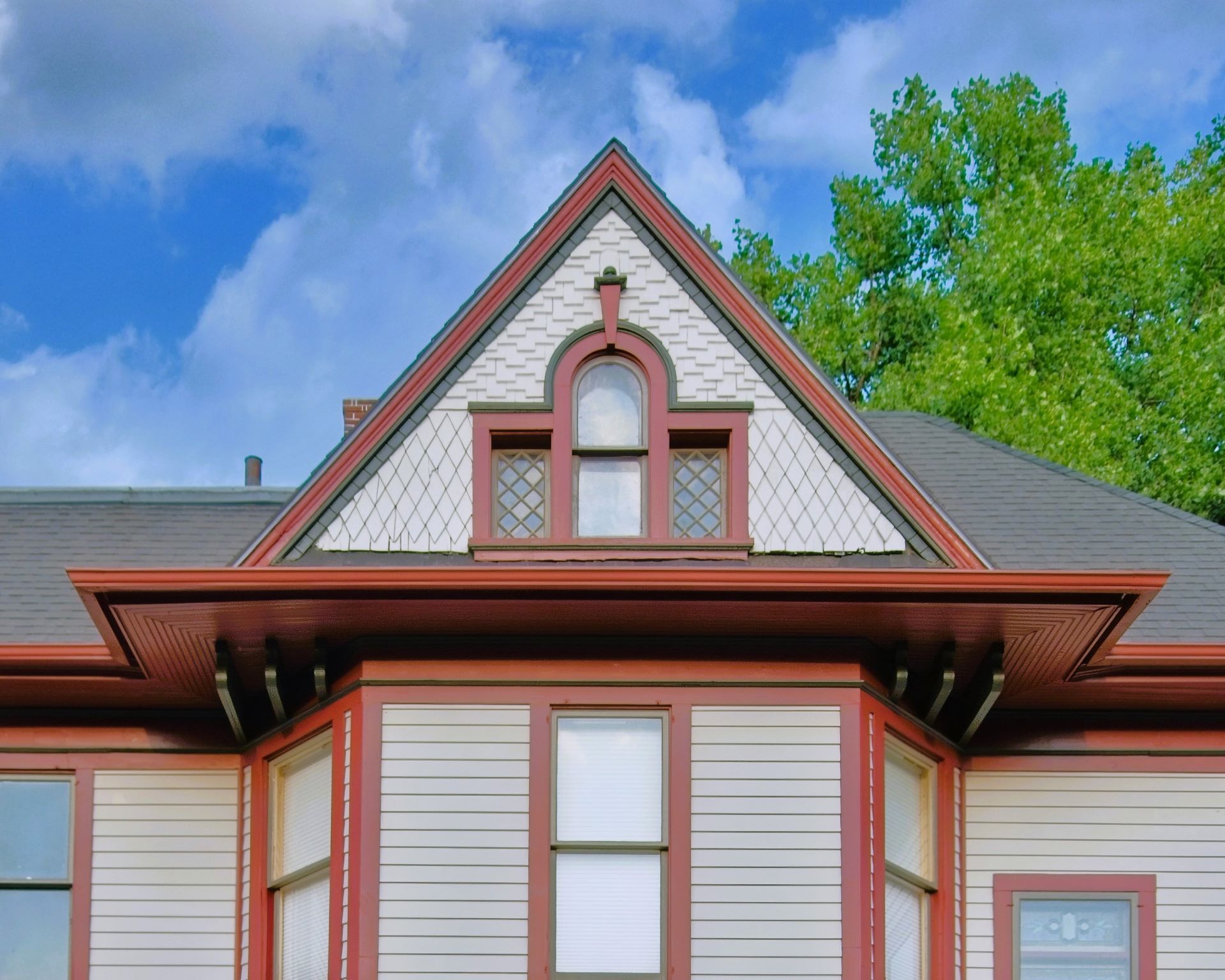 Close-up of the ornate attic gable and third-story arched window on the historic 1899 home at 504 W. Cavour Ave in Fergus Falls, Minnesota.