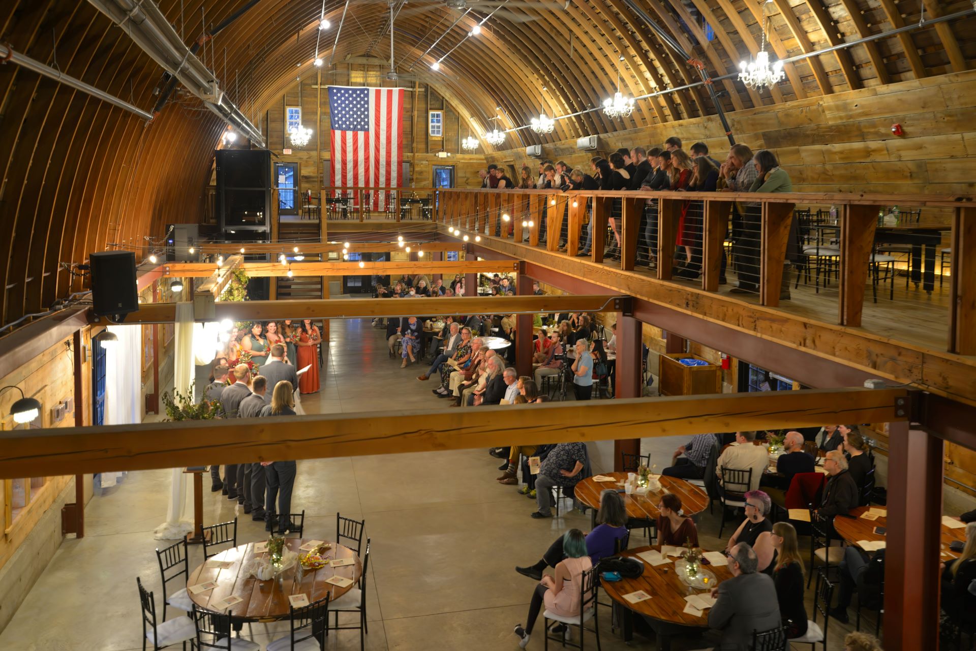 High angle wide shot of a wedding ceremony inside the historic John P. Furber Farm barn venue (The Madison) in Cottage Grove, Minnesota.