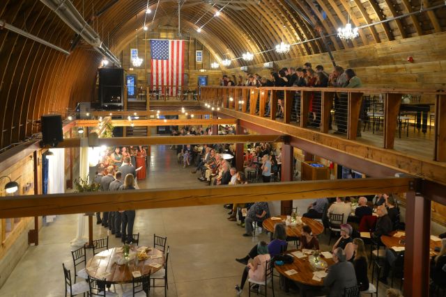 High angle wide shot of a wedding ceremony inside the historic John P. Furber Farm barn venue (The Madison) in Cottage Grove, Minnesota.