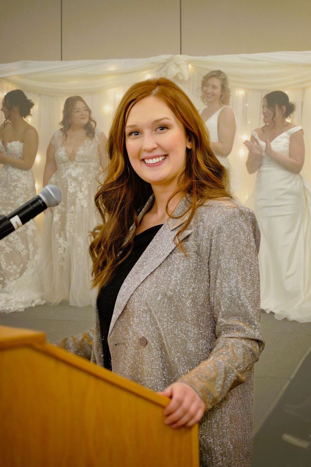 A lady from Fergus Falls, stands proudly by a podium, her day went well.