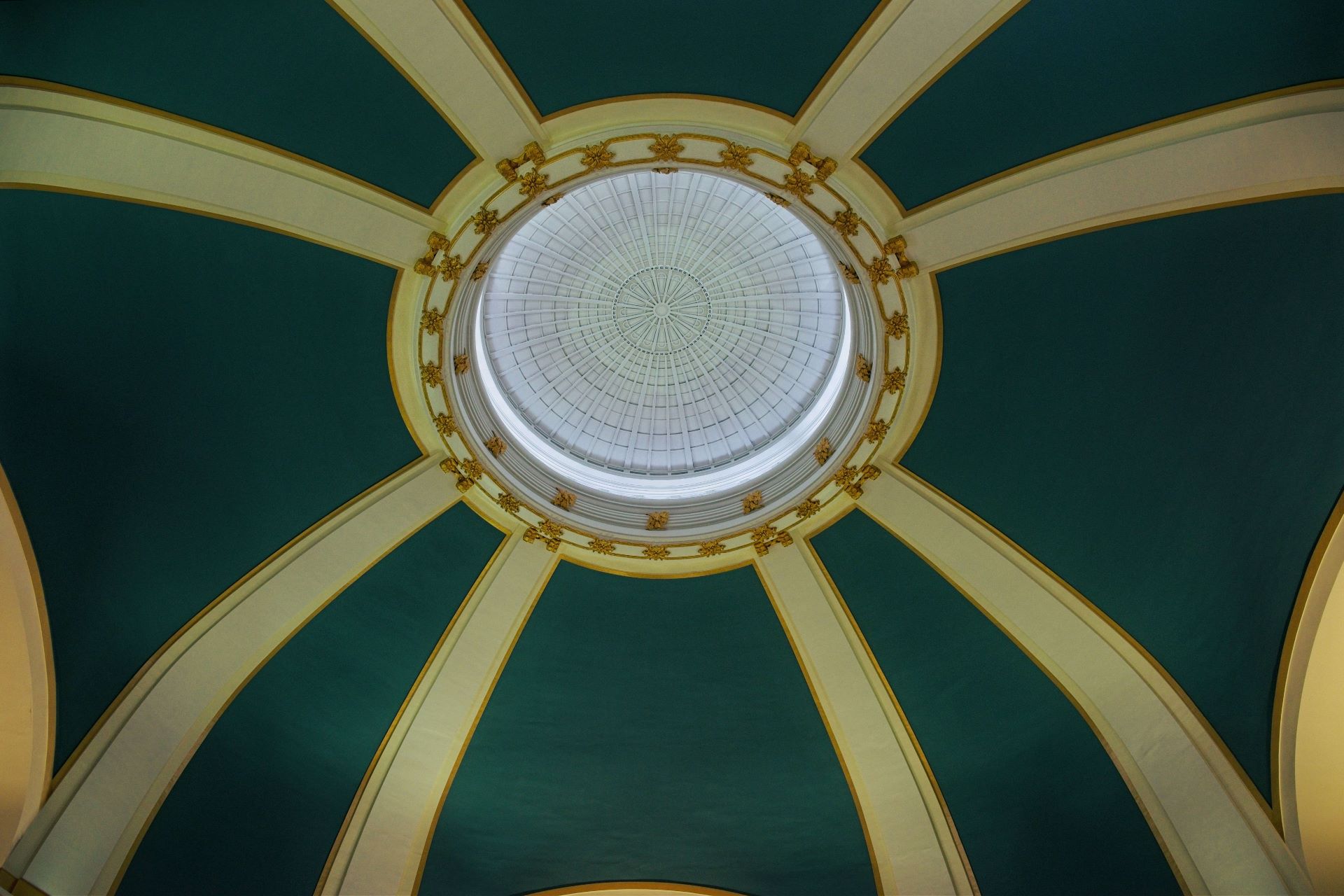 Symmetrical low-angle photograph looking straight up into the grand Beaux-Arts domed ceiling of Union Station in Winnipeg, Manitoba.