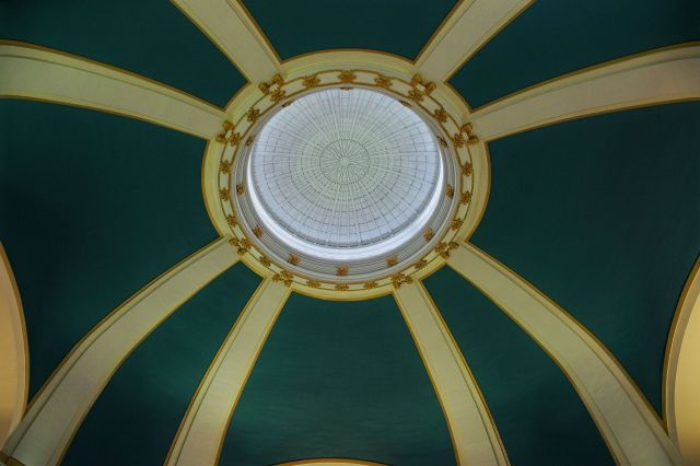 Symmetrical low-angle photograph looking straight up into the grand Beaux-Arts domed ceiling of Union Station in Winnipeg, Manitoba.