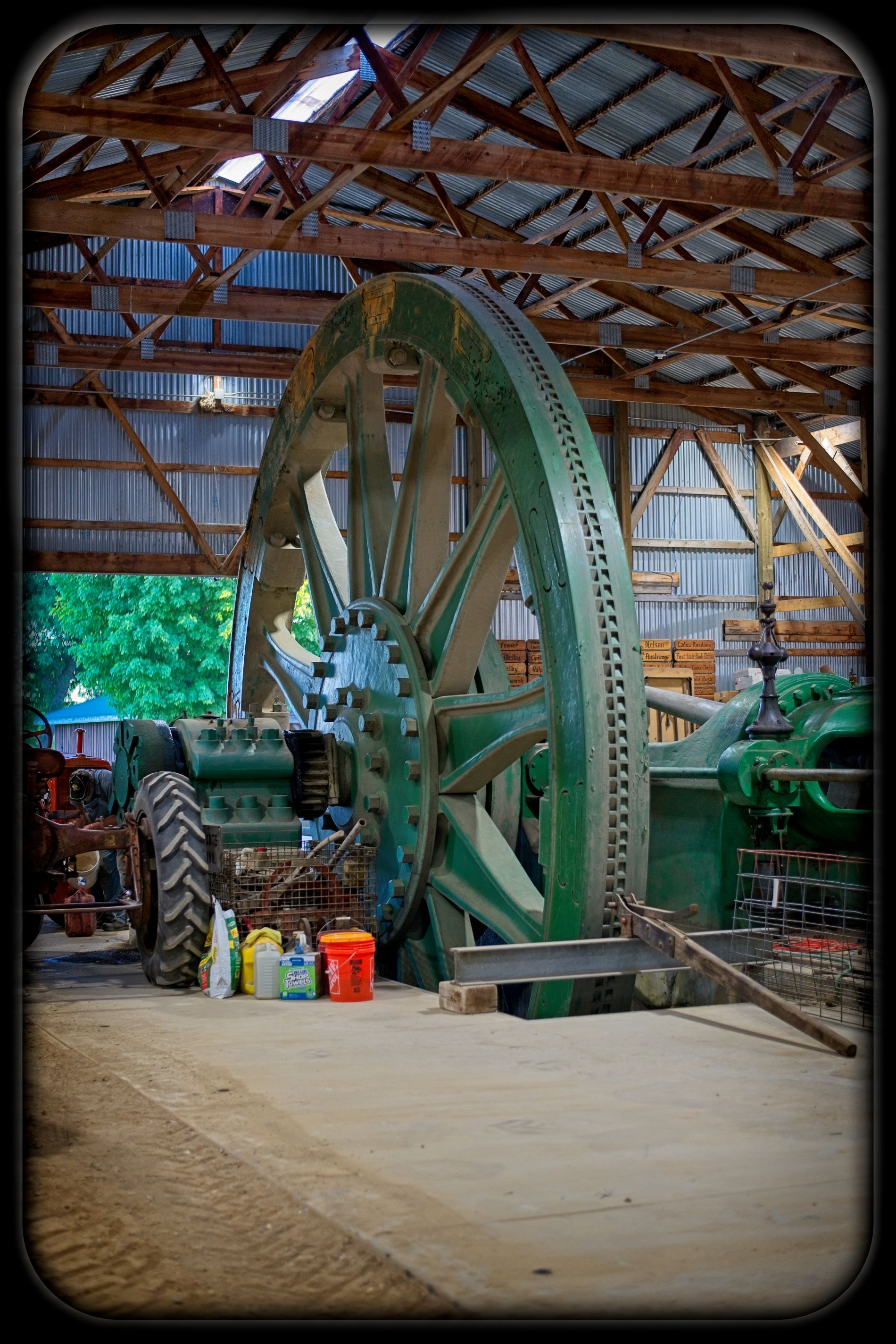 Massive green flywheel and machinery of the historic 110-ton Wheelock stationary steam engine inside the Wheelock Building at the Dalton Minnesota threshing grounds.