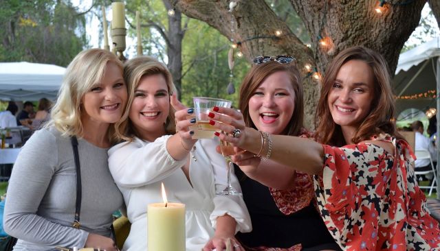 Bride in a white dress toasting with friends at an upscale outdoor wedding reception in Fergus Falls Minnesota.
